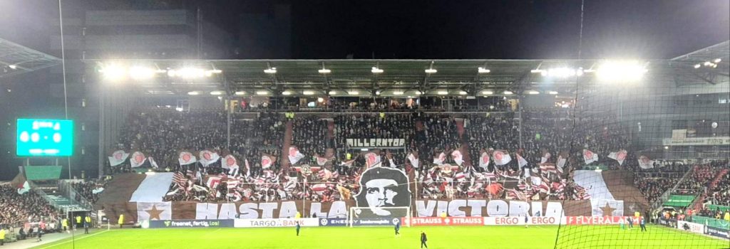 Südkurve im Millerntorstadion mit "Hasta La Victoria"-Banner und Konterfei von Che Guevara und viele St. Pauli-Fahnen.